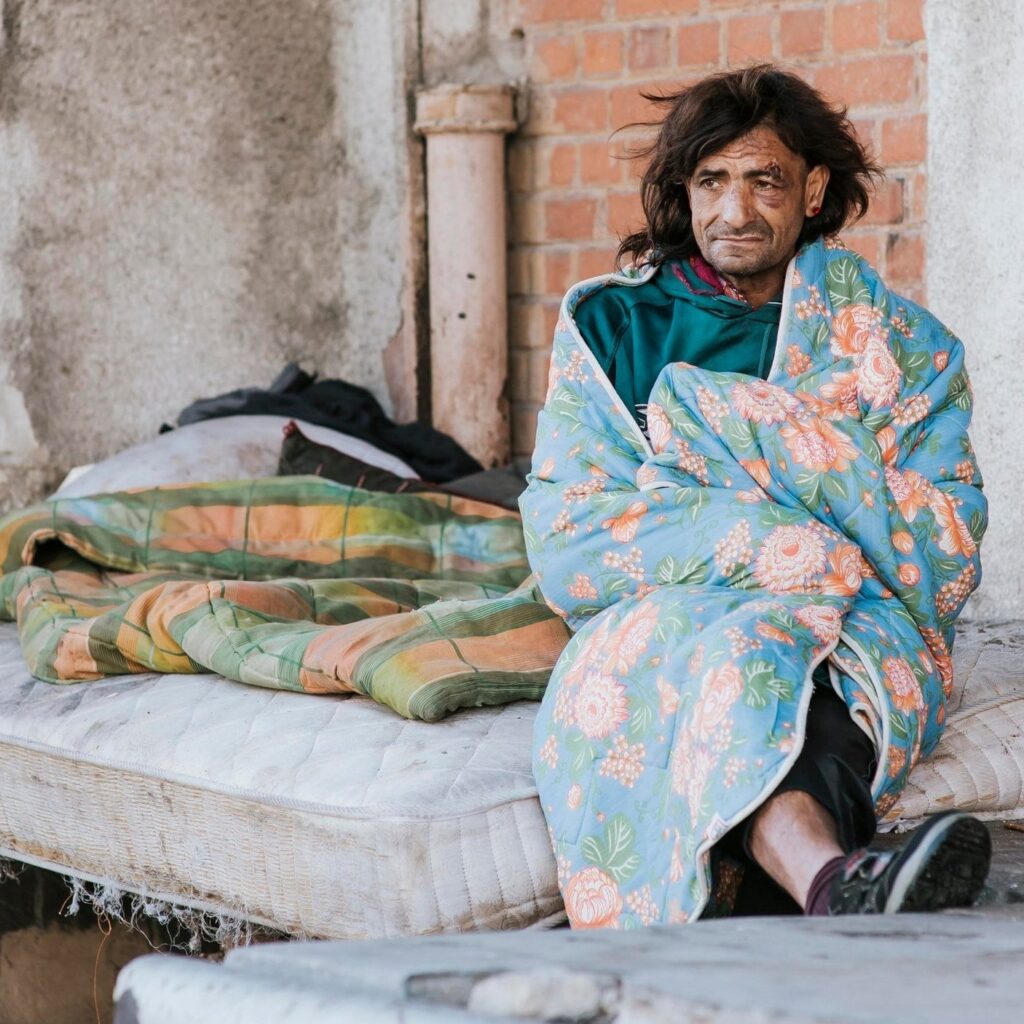 front-view-homeless-man-mattress-outside-blanket-min
